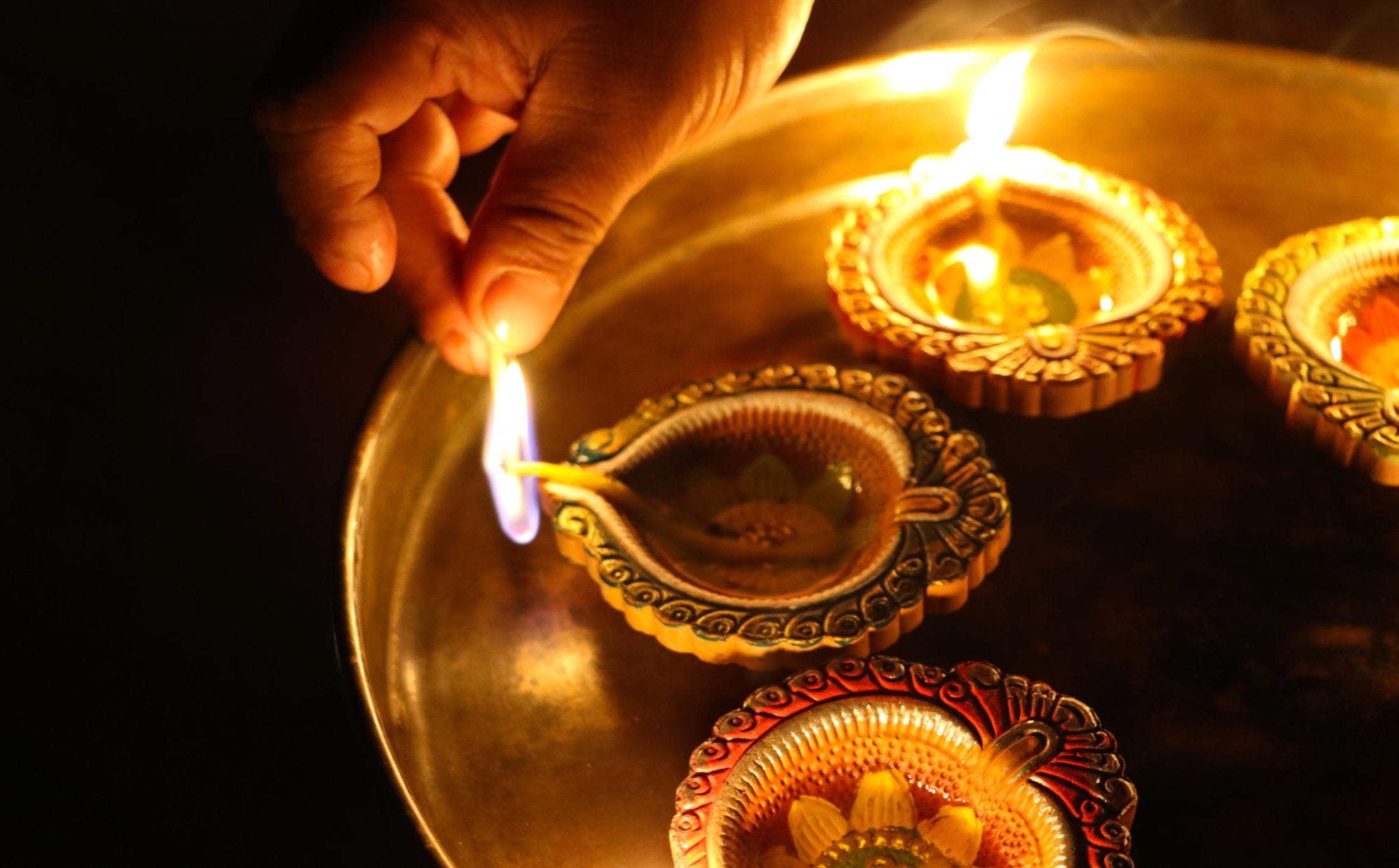 Sacred diya lighting with cotton wicks during Hindu pooja ritual